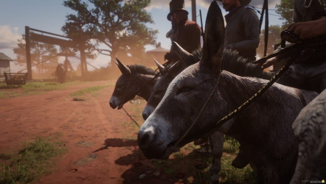 A posse riding mules together down a dusty road