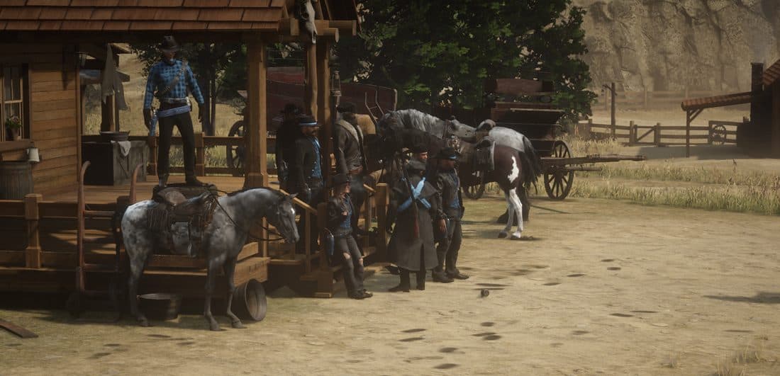 A gang gathered outside a homestead porch with their horses